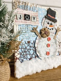 a snowman made out of buttons sitting on top of a wooden table