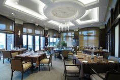 a dining room with tables and chairs set up for an event or function in front of large windows