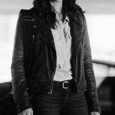 black and white photograph of a woman in a leather jacket with her hands in her pockets