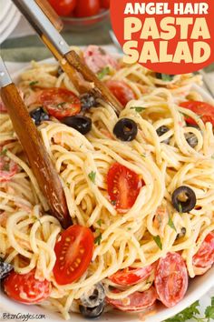 a plate full of pasta with olives, tomatoes and parsley on the side