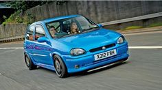 a blue car driving down the road with two people in it's passenger seat