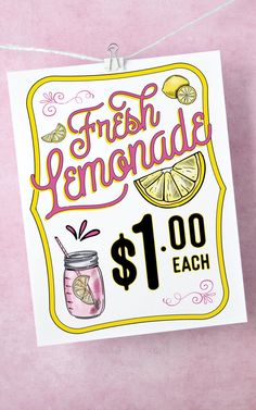 a sign advertising fresh lemonade hangs from a line on a pink background with white string