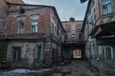 an alley way with old buildings and snow on the ground in front of one another