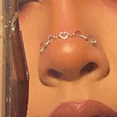 a nose piercing with a heart on it