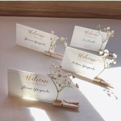 three place cards with flowers on them sitting on a table