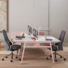 an office desk with two computer monitors on top of it and chairs in front of it