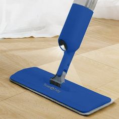 a blue dust mop is on the floor