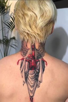 the back of a woman's neck with a skeleton and angel tattoo on it