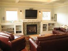 a living room filled with furniture and a flat screen tv mounted on the wall above a fire place