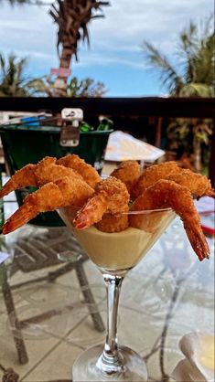 some shrimp sticks in a martini glass on a table