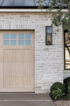 a white brick house with a wooden garage door