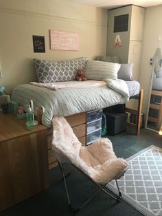 a bedroom with a bed, desk and chair in it's corner area next to a window