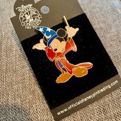 a mickey mouse pin sitting on top of a card