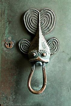 an old door handle with a face on it