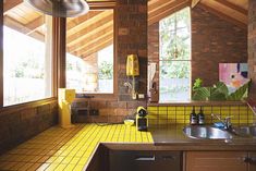 a kitchen with yellow tiles on the floor