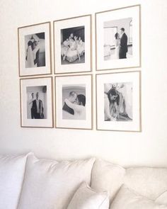 a white couch sitting next to a wall with pictures on it