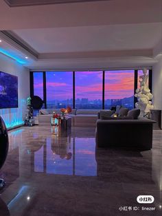 a large living room with floor to ceiling windows overlooking the cityscape at sunset