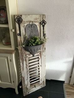 an old door is used as a planter for a potted plant in the corner