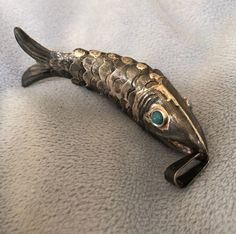 a fish shaped brooch sitting on top of a bed