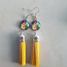 two yellow tasselled earrings with pictures on them