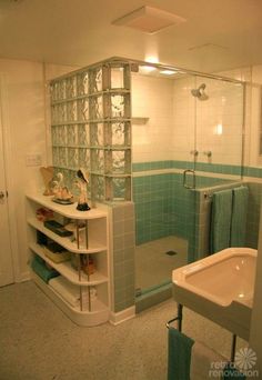 a bathroom with a sink, shower and shelves in the corner next to the bathtub