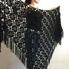 a black crocheted shawl hanging on a wall