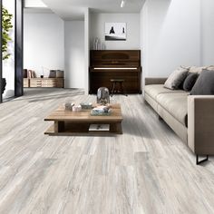 a living room filled with furniture and a wooden coffee table on top of a hard wood floor