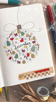 an open notebook with the words december written on it next to some crafting supplies