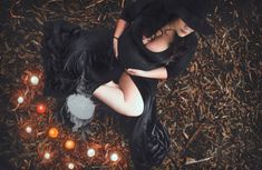 a woman laying on the ground surrounded by candles