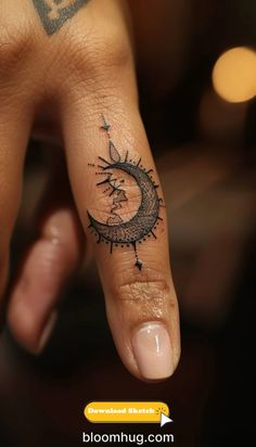 a person's hand with a small sun and moon tattoo on the middle finger