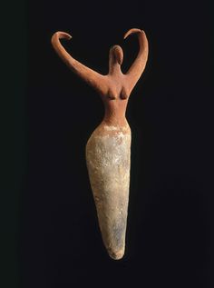 an old clay statue with a woman's head and arms extended in the air