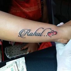 a person with a tattoo on their arm that says rabul and two hearts