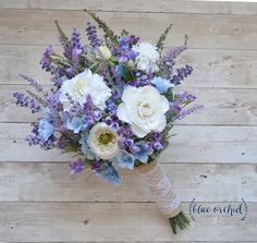 a bouquet of white and blue flowers on a wooden surface