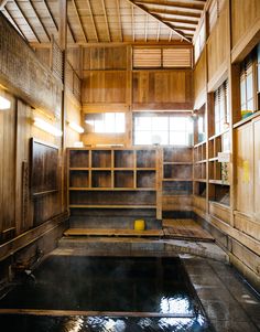 the inside of a wooden building with water in it and shelves on either side of the room