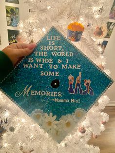 someone holding up a graduation cap that says life is short, the world is wide & i want to make some memories