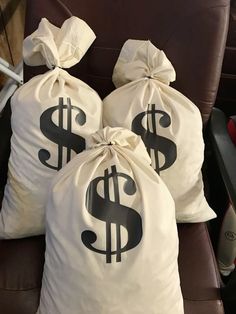 three bags filled with money sitting on top of a chair