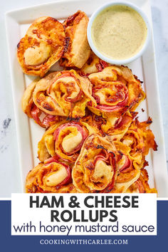 ham and cheese rolls with honey mustard sauce on a white platter next to a bowl of dip