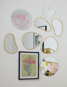 there are many mirrors on the wall and one is decorated with cartoon faces in different colors