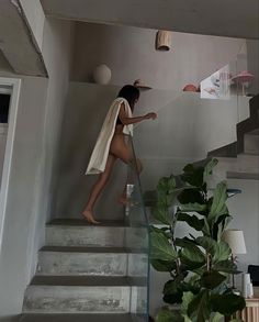 a woman is walking up the stairs with a towel over her head