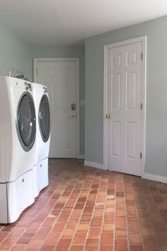 a washer and dryer are in the middle of a room with two doors