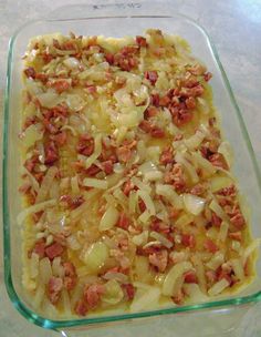 a casserole dish with meat and onions in it