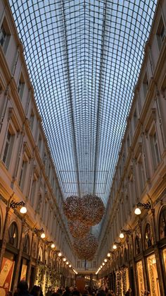 the inside of a shopping mall with many people walking around and looking up at the ceiling