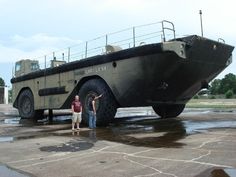 two people standing in front of an armored vehicle