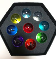 an assortment of different colored glass objects in a black box