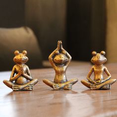 three small figurines sitting on top of a wooden table