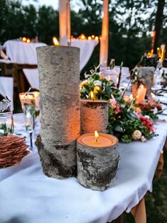 two candles are sitting on a table with flowers