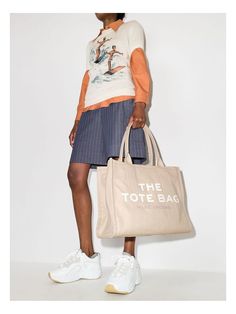 Expertly crafted with durable cotton canvas, this large tote bag features a secure top zip closure and a convenient top handle. Stay organized on the go with 1 interior zip pocket and 2 slip pockets. Perfect for everyday use and travel. 17in L x 6in D x 13in H 42cm L x 16cm D x 34cm H Handle Drop 9in (24cm) | Marc Jacobs The Canvas Large Tote Bag in Beige | M0016156 Color 260 Stitching Logo, Beige Tote Bag, Beige Tote, Marc Jacobs Handbag, Marc Jacobs Tote, The Tote Bag, Marc Jacobs Bag, Canvas Shopping Bag, Large Tote Bag