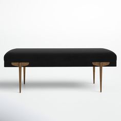 an upholstered bench with wooden legs and a black fabric cover on the top