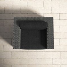 an overhead view of a black chair against a white brick wall