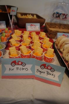 an assortment of snacks are displayed on a table with signs that say air filters, engine blocks and cheetos